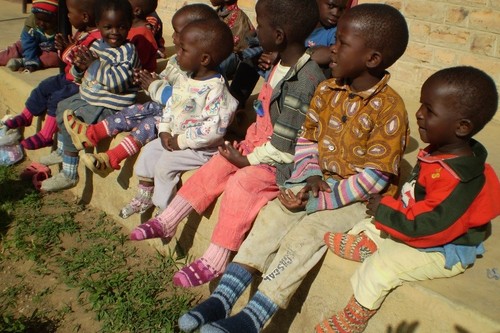 Lähetystukirenkaan kutomia villasukkia orpokodin lapsilla Tansaniassa.